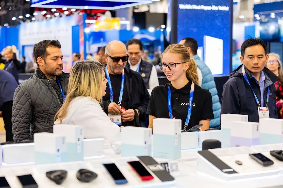 CES 2026 Um grupo de pessoas sorridentes conversa no estande da Vasco Electronics na CES 2026.